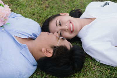High angle view of young couple lying on grass