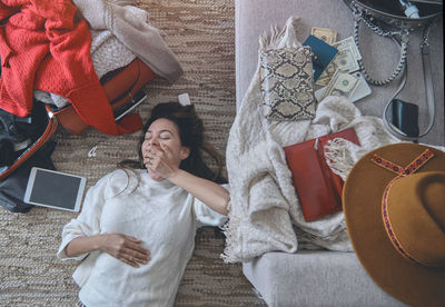 Young woman just arrived in the hotel and relaxing at the floor after a long flight