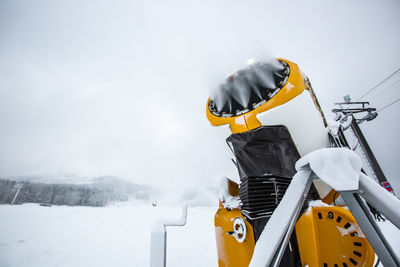 Yellow umbrella on snow against sky