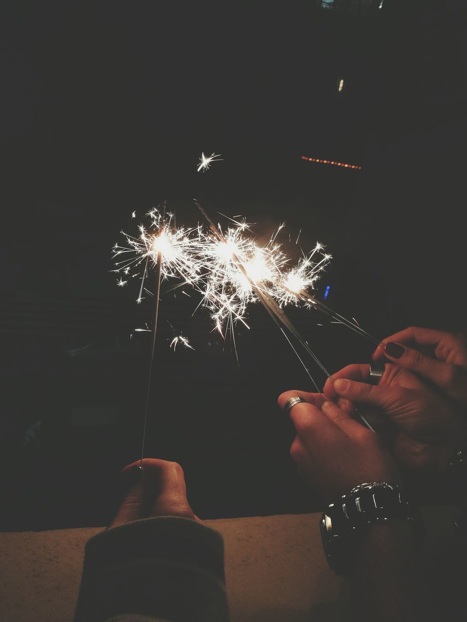 human hand, human body part, night, low angle view, people, adults only, firework - man made object, men, celebration, firework display, sparkler, adult, women, motion, one person, exploding, illuminated, only men, black background, teamwork, outdoors, firework