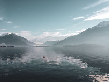 Scenic view of sea and mountains against sky