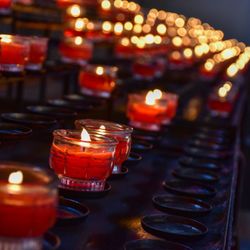Illuminated tea light candles in row at church