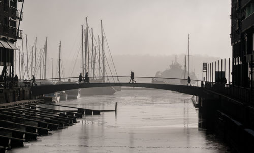 Bridge over river in city against sky