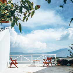 Chair by sea against sky