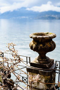 Close-up of statue by sea against sky