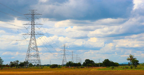 Electricity pylon on field against sky
