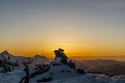 Scenic view of snowcapped mountains against sky during sunset