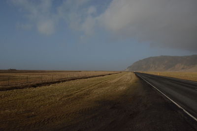 Empty road along countryside landscape