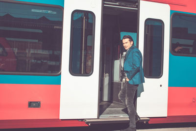 Portrait of man standing at door of train