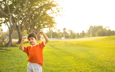 Boy standing in park against clear sky