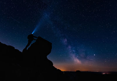 Silhouette man standing against star field at night