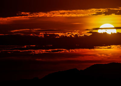 Scenic view of silhouette mountains against romantic sky at sunset