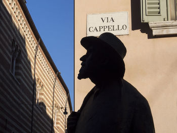 Close-up of silhouette person holding mobile phone against sky