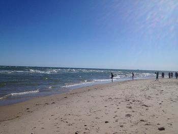 Scenic view of beach against clear blue sky