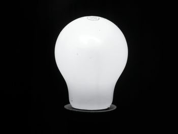 Low angle view of light bulb against black background