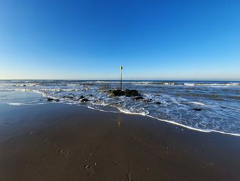 Scenic view of sea against clear blue sky