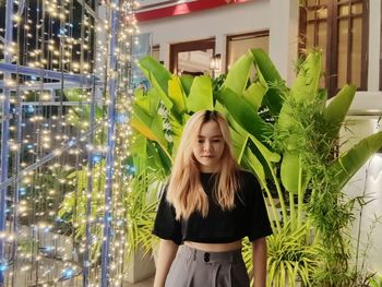 Young woman standing amidst plants