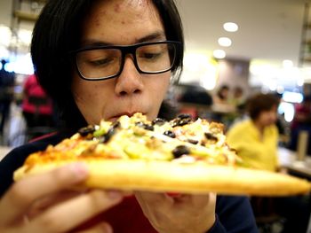 Close-up of teenage boy eating pizza