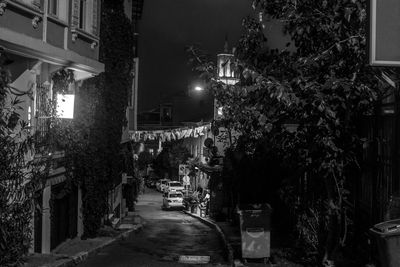 Narrow street amidst buildings at night