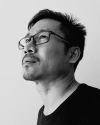 Portrait of young man wearing eyeglasses against white background