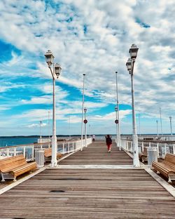 Rear view of person on pier against sky