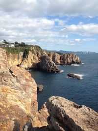 Rock formations by sea against sky