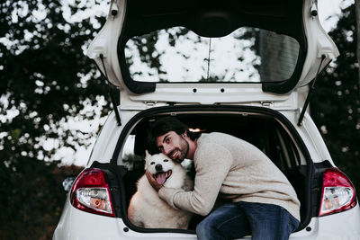 Portrait of woman with dog in car