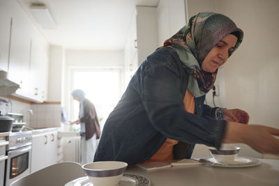 Women in headscarves cooking together for eid al-fitr at home