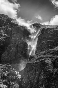 Low angle view of waterfall against sky