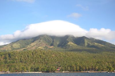 Scenic view of lake by mountains against sky