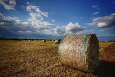 Hay bales on field against sky