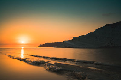 Scenic view of sea and scala dei turchi  during sunset