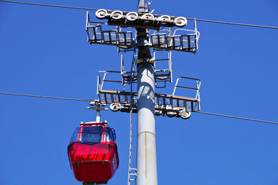 Low angle view of overhead cable car against blue sky
