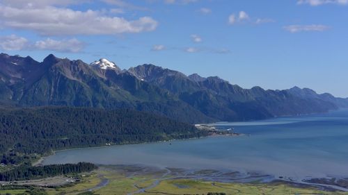 Scenic view of sea and mountains against sky