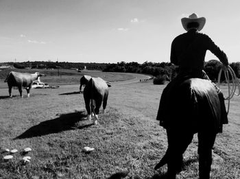 Statues of cowboy and cattle on landscape