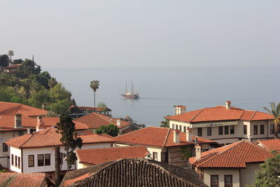 Boats in sea with houses in background