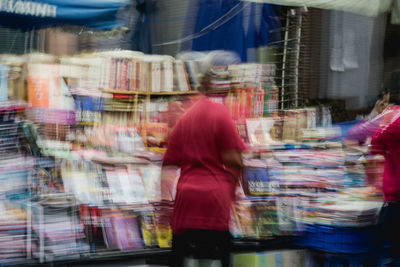 Rear view of woman with umbrella in store