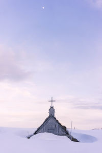 Built structure on snow covered landscape against sky