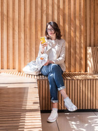 Woman is texting on smartphone while eating tasty pastry. scrolling social media. coffee break