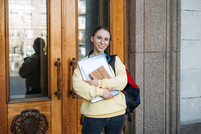 Mixed race college student girl enters the doors of the university, college.