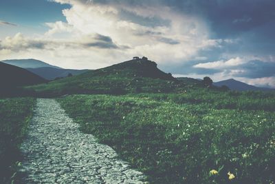 Scenic view of mountains against cloudy sky