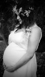 Midsection of woman standing by flowers