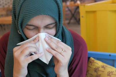 Closeup on ill elegant woman wiping nose with napkin