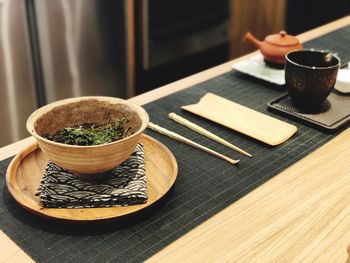 Soup with herbs in bowl on table at restaurant