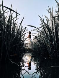 Girl standing by lake against sky