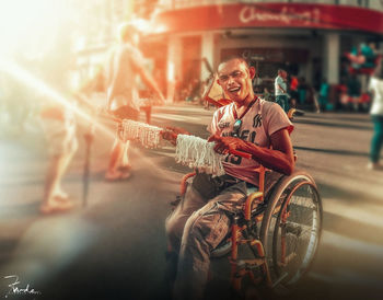 Portrait of smiling man sitting on street in city