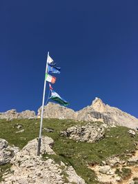 Flag on mountain against clear blue sky