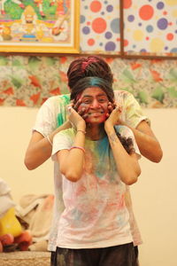 People playing holi against wall