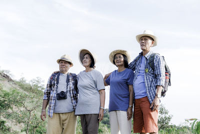 Portrait of friends standing against the sky