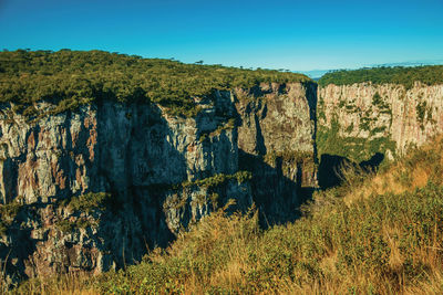 Itaimbezinho canyon with steep rocky cliffs going through a flat plateau, in cambará do sul, brazil.